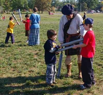 Angus Fraser instructs two Cub Scouts in proper distance while Squire Riochard watches two other scouts battle.