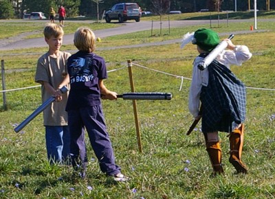 Page Christopher watches two Cub Scouts battle with padded weapons.